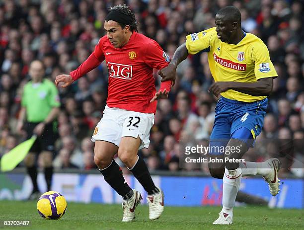 Carlos Tevez of Manchester United clashes with Seyi Olofinjana of Stoke City during the Barclays Premier League match between Manchester United and...