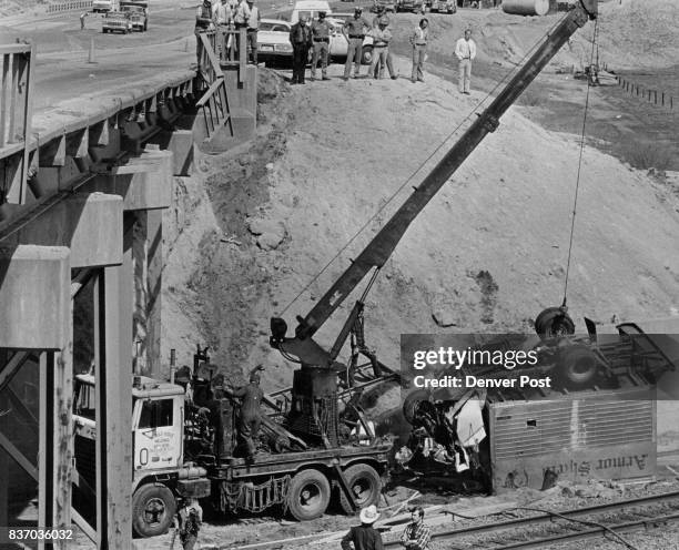 Truck Crash Tears Out 100 Feet Of Guard Rail On Interstate 25 to lift the overturned wreckage of a Petro Mark Inc. Truck plunged off a railroad over...