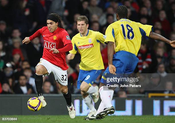 Carlos Tevez of Manchester United clashes with Richard Cresswell and Salif Diao of Stoke City during the Barclays Premier League match between...
