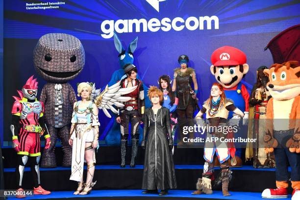 People dressed up as game characters are seen during the opening ceremony of gaming fair "gamescom" in Cologne on August 22, 2017. / AFP PHOTO /...