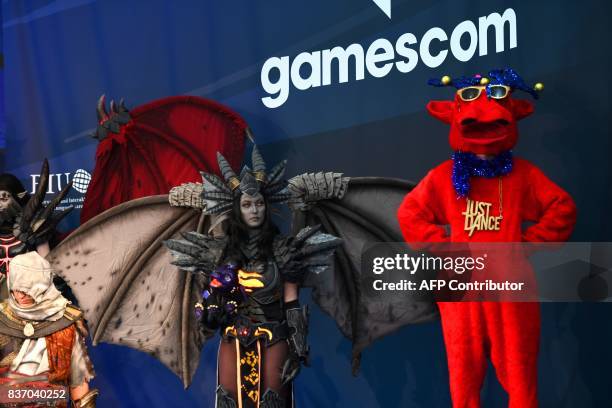 People dressed up as game characters are seen during the opening ceremony of gaming fair "gamescom" in Cologne on August 22, 2017. / AFP PHOTO /...