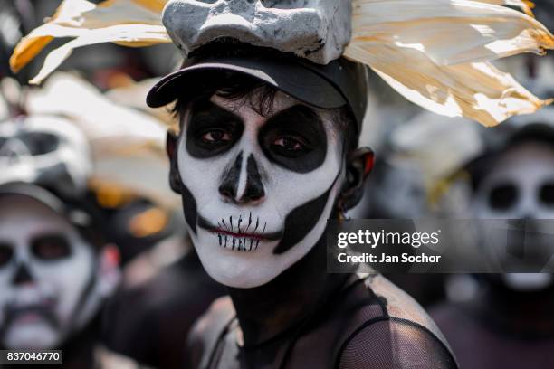 Mexican man, wearing a skull mask and his face painted as Calaca theme, performs in the street during the Day of the Dead festival on October 29,...