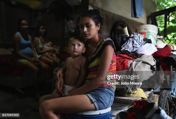Laura Guevara holds her son Emerson, 14 months, outside her one-room home in an impoverished neighborhood on August 19, 2017 in San Pedro Sula,...