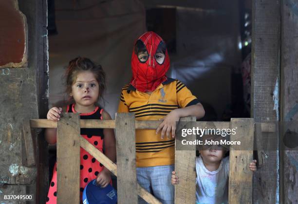 Children stand at the front of their family's one-room home in an impoverished neighborhood on August 19, 2017 in San Pedro Sula, Honduras. Honduras...