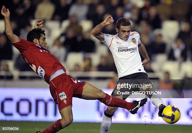 Valencia's Juan Mata vies with Sporting Gijon's Sastre during their Spanish league football match at Mestalla Stadium in Valencia, on November 15,...