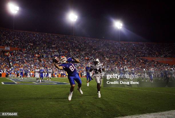 Tight end Aaron Hernandez of the Florida Gators catches a fourth quarter touchdown pass over safety Darian Stewart of the South Carolina Gamecocks at...