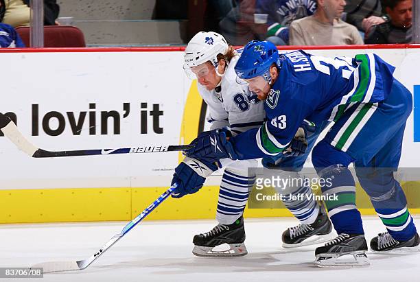Mikhail Grabovski of the Toronto Maple Leafs and Henrik Sedin of the Vancouver Canucks race for the puck during their game against the Toronto Maple...