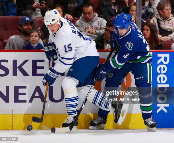 Tomas Kaberle of the Toronto Maple Leafs skates away from a check by Henrik Sedin of the Vancouver Canucks during their game against the Toronto...