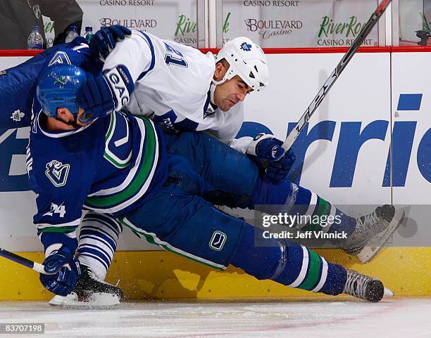 Darcy Hordichuk of the Vancouver Canucks finishes a big hit on Jamal Mayers of the Toronto Maple Leafs during their game against the Toronto Maple...