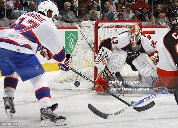 Martin Biron of the Philadelphia Flyers prepares to stop a shot from Georges Laraque of the Montreal Canadiens during their NHL game at the Bell...