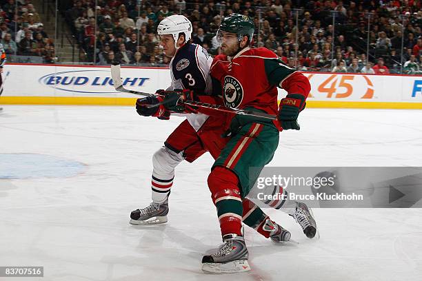 Brent Burns of the Minnesota Wild and Marc Methot of the Columbus Blue Jackets skate to the puck during the game at the Xcel Energy Center on...