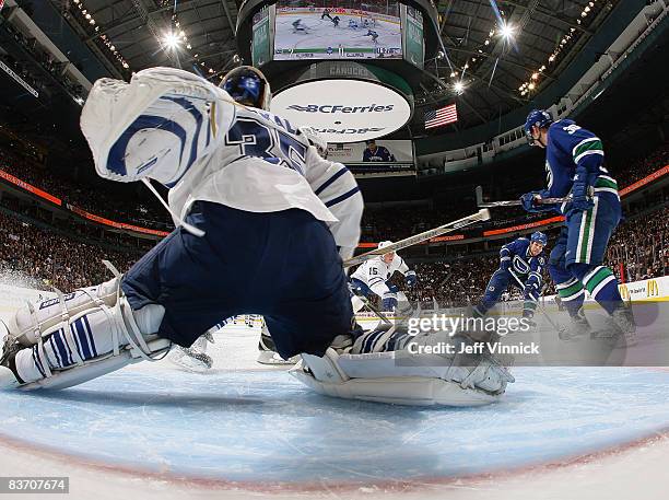 Willie Mitchell of the Vancouver Canucks shoots the puck Vesa Toskala of the Toronto Maple Leafs for his first goal of the year during their game at...