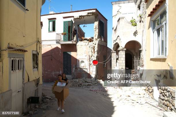 People carry belongings from they damaged homes in Casamicciola Terme, on the Italian island of Ischia, on August 22 after an earthquake hit the...