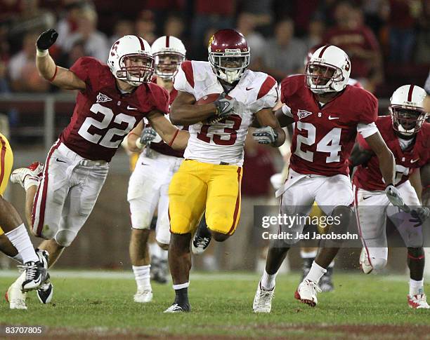 Stafon Johnson of USC Trojans runs against Bo McNally and Kris Evans of the Stanford Cardinal in the first half at Stanford Stadium on November 15,...