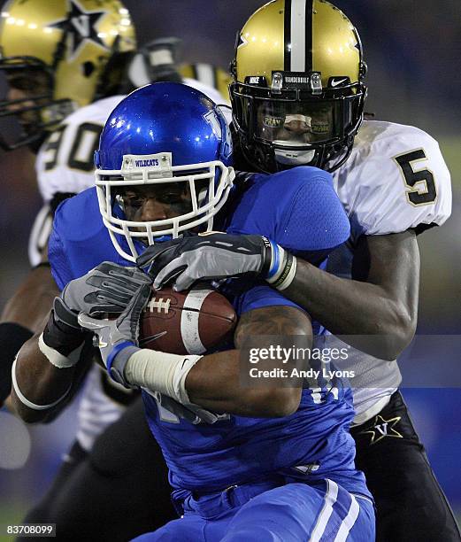 Adams of the Kentucky Wildcats is tackled by Myron Lewis of the Vanderbilt Commodores during the game on November 15, 2008 at Commonwealth Stadium in...