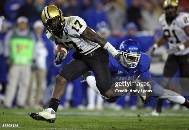 Moore of the Vanderbilt Commodores runs with the ball while defended by Marcus McClinton of the Kentucky Wildcats during the game on November 15,...