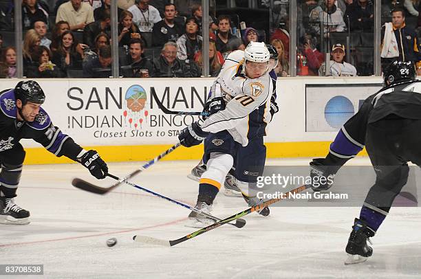 Martin Erat of the Nashville Predators passes the puck as Jarret Stoll and Alexander Frolov of the Los Angeles Kings defends during the game on...