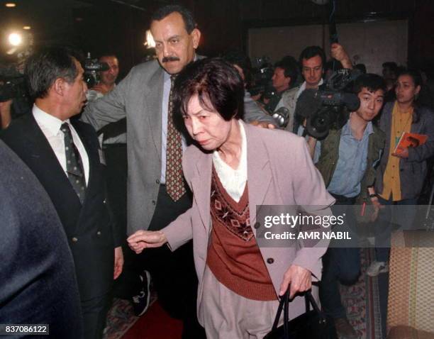 An unidentified Japanese woman, a relative to a victim of the Luxor massacre, is escorted past journalists and cameramen at the Cairo airport 19...