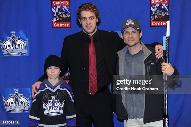Anze Kopitar of the Los Angeles Kings poses for a photo with Actor Christian Slater and son after the game against the Nashville Predators on...