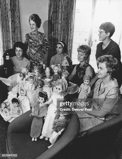 Mrs. Genevia Merrick Hunt, standing left, and others who helped renew dolls are pleased with "after" effects. From left: Mmes, Allen Bailey, O.L....