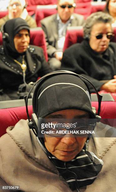 Blind and partially sighted people follow a film using the audio description system, an additional commentary during the movie describing body...