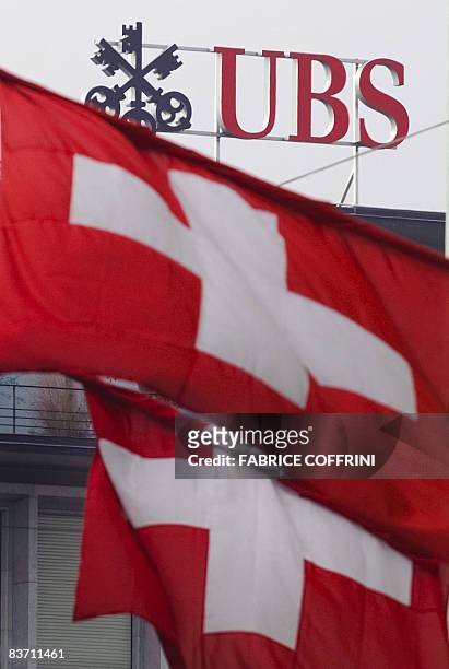 Two Swiss flags fly above a logo of the UBS on the top of the Swiss banking giant headquarters, on November 15, 2008 in Zurich. A month ago,...