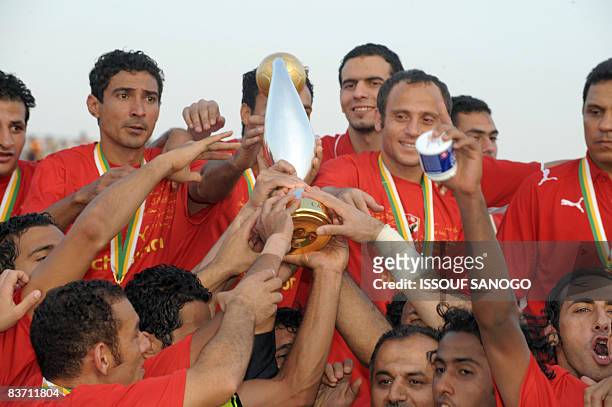 Egypt's Al-Ahly players hold the African Champions League trophy after drawing 2-2 with Cotonsport Garoua of Cameroon in the second leg of the final...