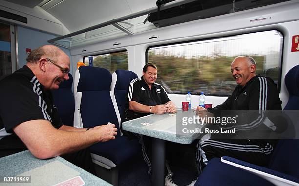 Mike Cron, Steve Hansen and Gilbert Enoka of the New Zealand All Blacks play cards as the team travel by train from Dublin to Limerick on November...
