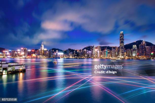 the world famous night scene of hong kong city skyline with busy water traffic navigate across victoria harbour - hong kong imagens e fotografias de stock