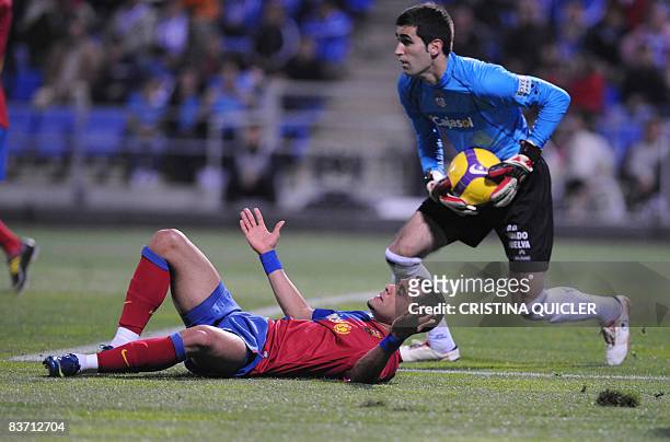 Barcelona's Daniel Alves vies with Recreativo Huelva's goalkeeper Asier Riesgo during their Spanish league football match at the Nuevo Colombino's...