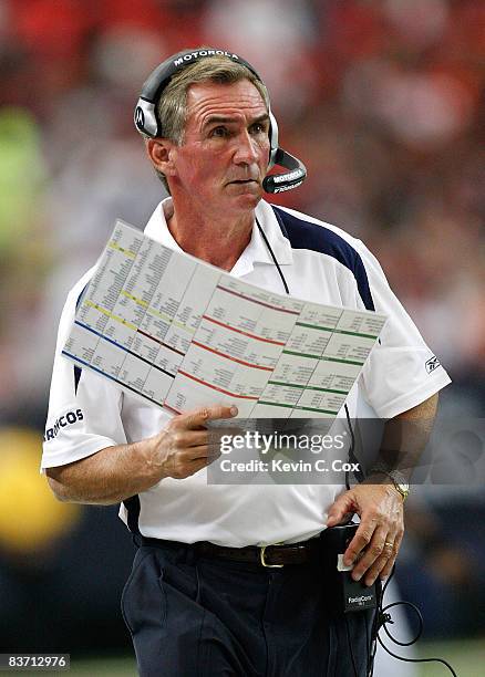 Head coach Mike Shanahan of the Denver Broncos looks at his playbook against the Atlanta Falcons during the game at the Georgia Dome on November 16,...