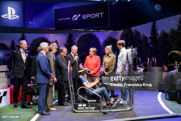 German Chancellor Angela Merkel, Sean Casey, Henriette Reker, Felix Falk, Armin Laschet and Gerald Boese visit the Sony Gran Turismo stand with Jim...