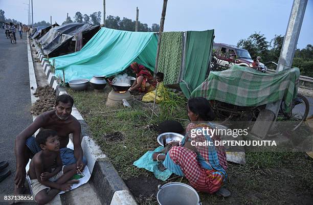 Indian flood effected villagers cooks food in temporary shelters along National Highway 34 as their houses were submerged by flood waters in Gazole...