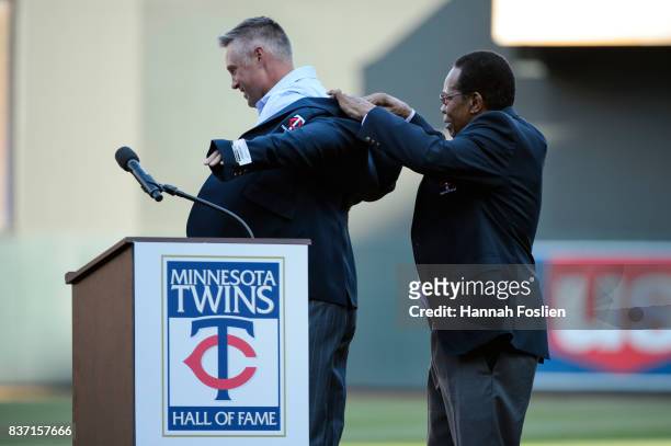 Hall of fame player Rod Carew presents former Minnesota Twins player Michael Cuddyer with a jacket as Cuddyer is inducted into the Minnesota Twins...