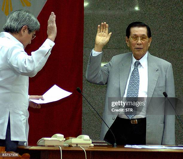 Philippine senator Juan Ponce Enrile is sworn in by fellow Senator Gringo Honasan as the new Senate president in Manila on November 17, 2008. A...