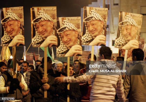 Palestinians hold placards bearing a portrait of late leader Yasser Arafat during a rally to mark Independence Day in the West Bank town of Bethlehem...