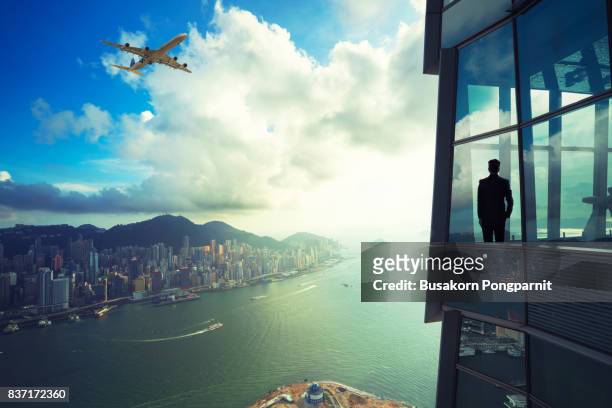 businessman standing in modern room office with looking at cityscape - asian ceo stock-fotos und bilder