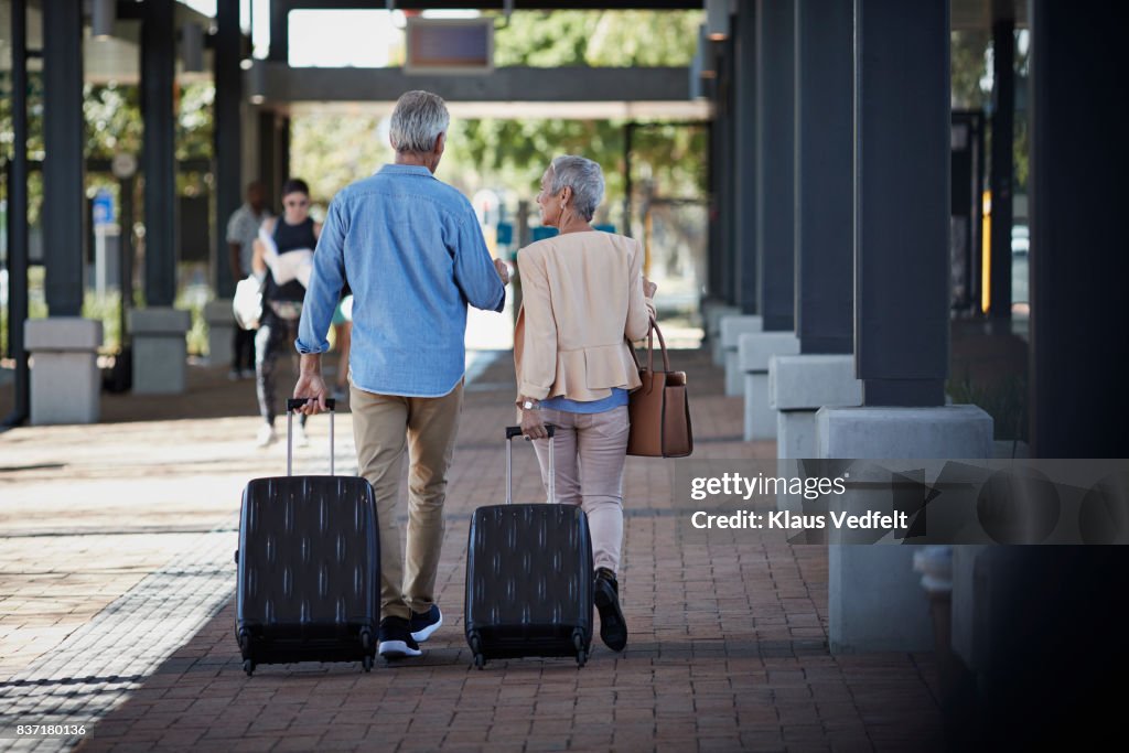 Senior couple walking together on public transport station
