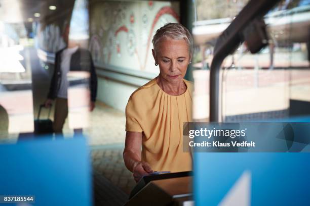 senior woman checking out at metro station - retirement card stock pictures, royalty-free photos & images