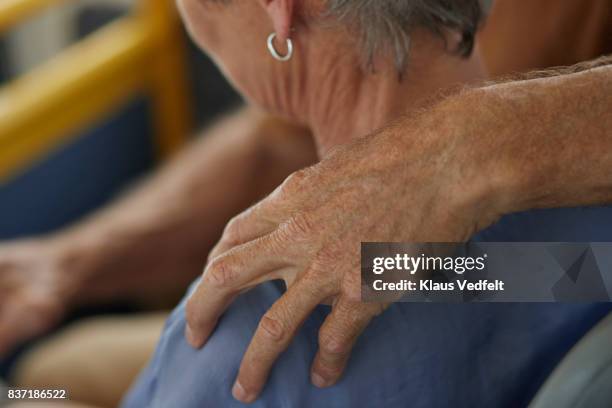 close-up of senior man with hand on shoulder of his wife - man touching shoulder stock-fotos und bilder