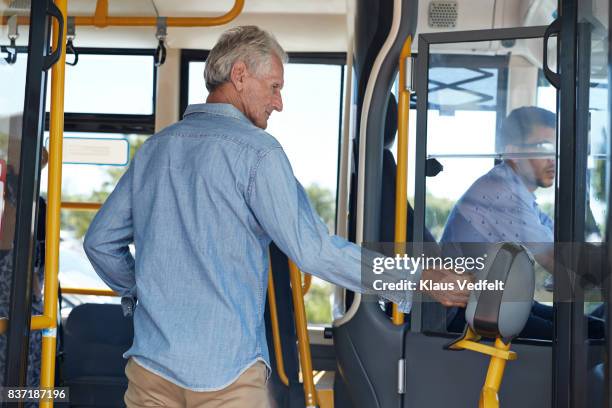 mature man using travel card to pay for bus ride - contactless payment bus stock pictures, royalty-free photos & images
