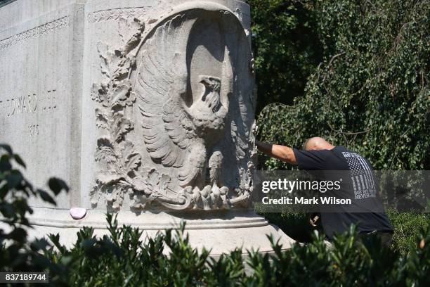 Richard Layne, an Iraq and Afghanistan veteran, pauses for a moment while touching the base of the Confederate Gen. Robert E. Lee statue that stands...