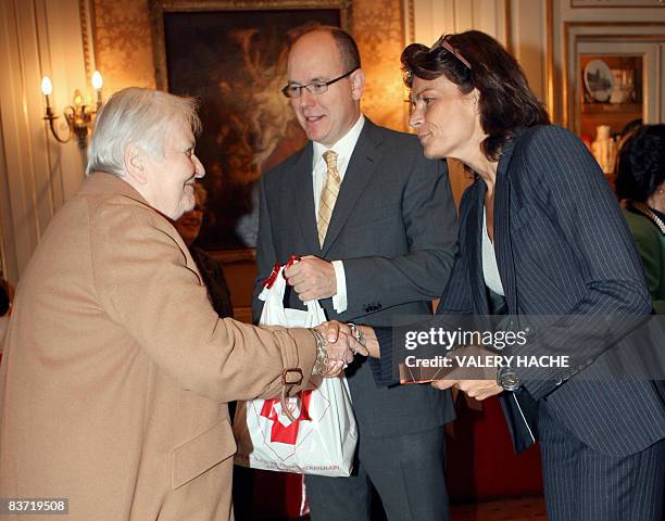 Prince Albert II and Princess Stephanie de Monaco give parcels to Monoca's residents at the Red Cross headquarters in Monaco during an annual charity...