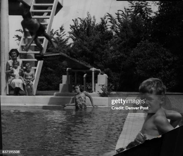 The ten-foot diving board at the home of the Chappell Cranmers forms an impressive background for 6-year-old Billy Mahn's plunge. Supervising the...