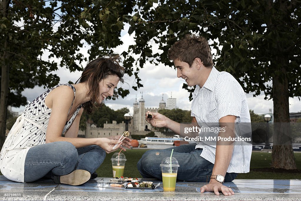 Couple enjoying sushi picnic in London park