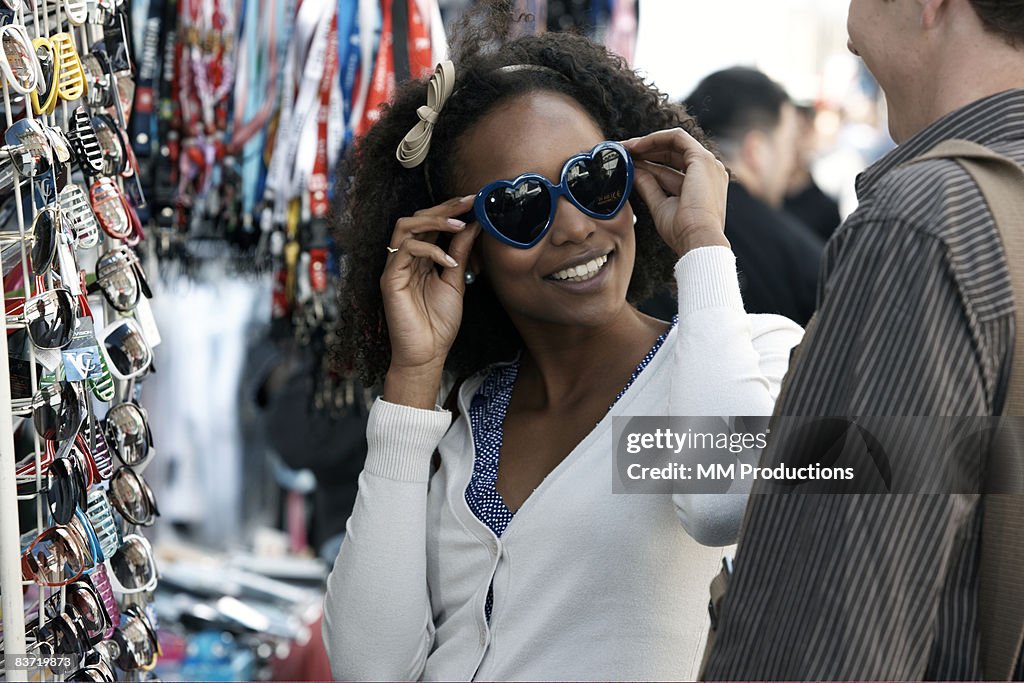 Woman trying on sunglasses with friend