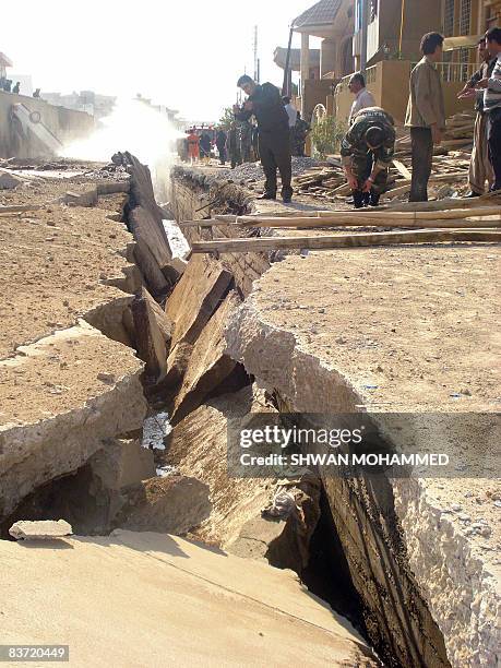 People gather at the scene of a gas pipe explosion along a street in the northern Kurdish city of Sulaimaniyah, some 330 kms from the capital Baghdad...