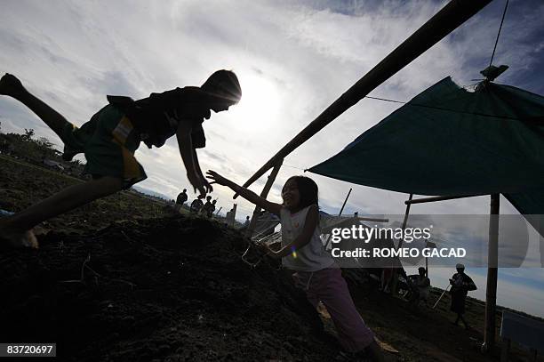 Kyle Binondo and Kaye Hoyohoy play at the disputed sugar farmland occupied by landless farmers in Santa Catalina town in Negros Oriental province in...