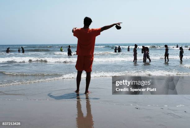 Lifeguard warns swimmers along Rockaway Beach as visitors try to stay cool on a hot summer day on August 22, 2017 in the Queens borough of New York...