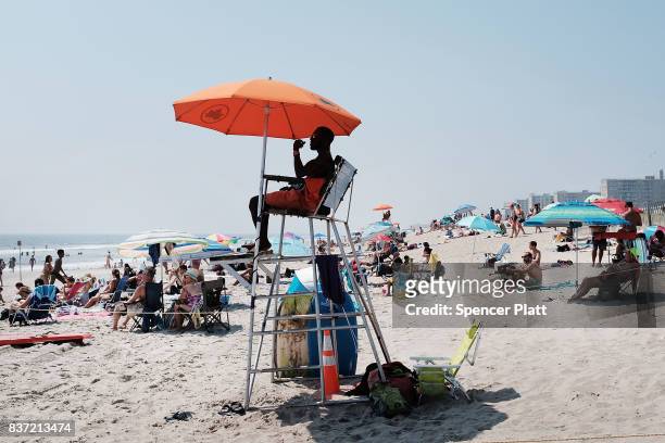 Lifeguard keeps watch over swimmers along Rockaway Beach as visitors try to stay cool on a hot summer day on August 22, 2017 in the Queens borough of...